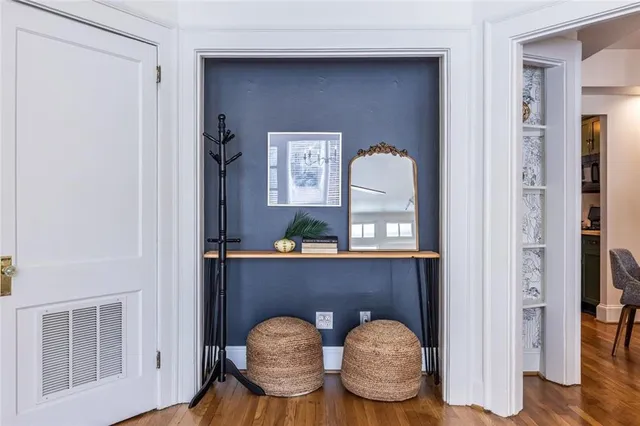 a living room with couches chairs and wooden floor