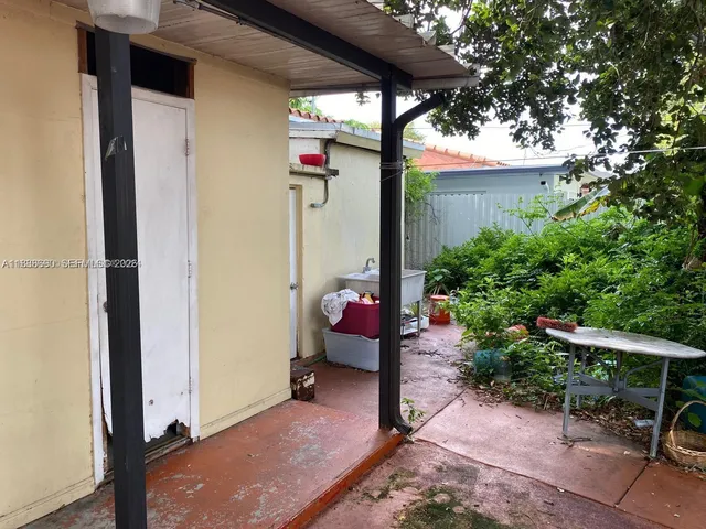 a backyard of a house with table and chairs