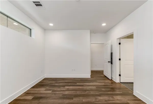 a view of empty room with wooden floor