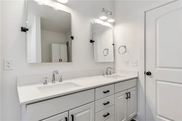 a bathroom with a sink double vanity and a mirror