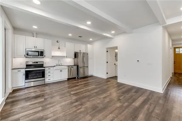 a kitchen with stainless steel appliances a refrigerator and a stove top oven