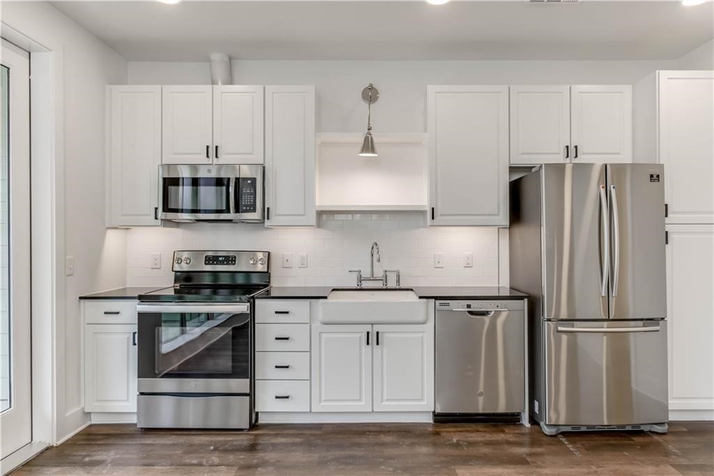 4704 Sunset Trail, Unit 3102 Austin, TX 78745 - Photo 4 of 40 a kitchen with stainless steel appliances white cabinets a sink and a stove