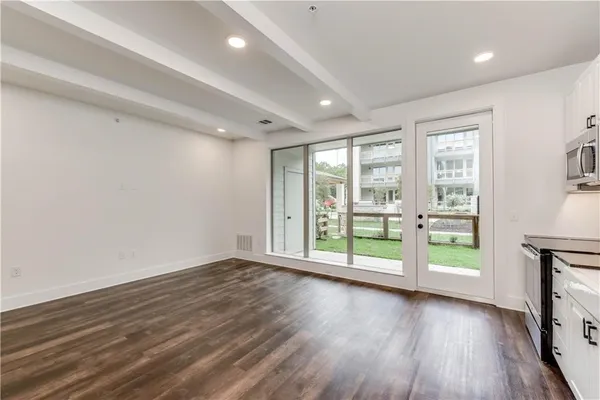 an empty room with wooden floor and windows