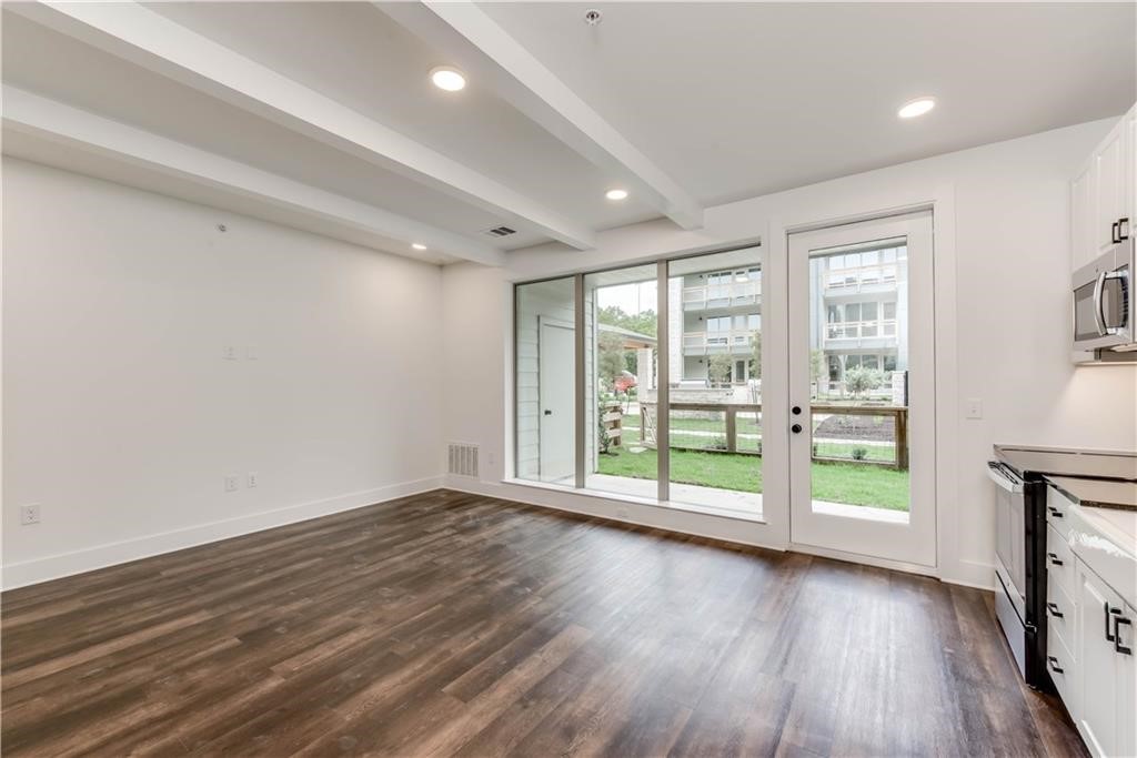 4704 Sunset Trail, Unit 3102 Austin, TX 78745 - Photo 7 of 40 an empty room with wooden floor and windows