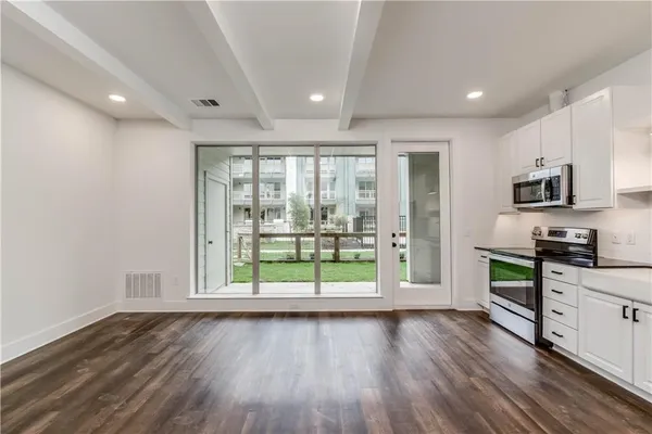 a view of kitchen with wooden floor and electronic appliances