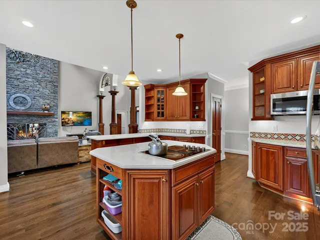 a kitchen with stainless steel appliances granite countertop a sink a stove and a wooden floor