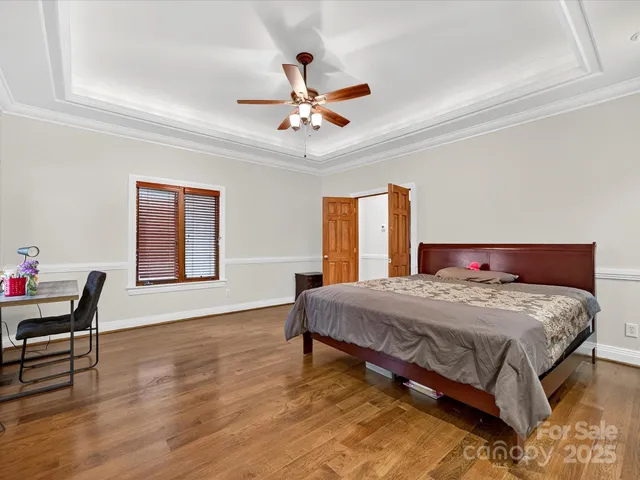 a bedroom with a bed and a ceiling fan