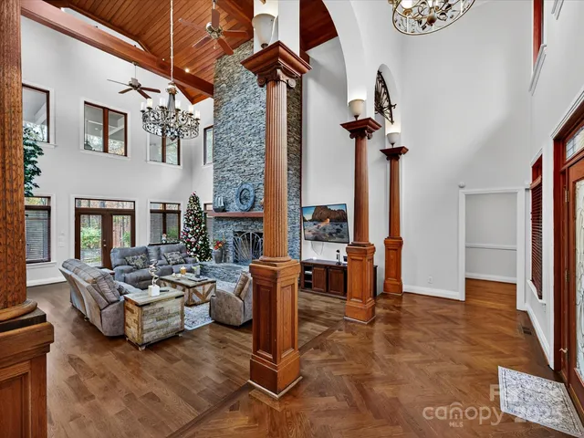 a living room with furniture floor to ceiling window and a flat screen tv