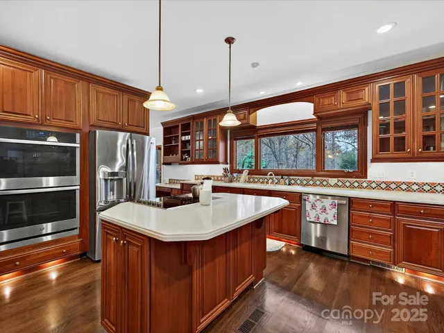 a kitchen with stainless steel appliances granite countertop a sink a stove and a refrigerator