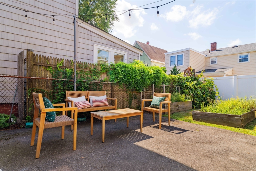 16 Partridge Avenue Somerville, MA 02145 - Photo 29 of 32 a backyard of a house with a garden and outdoor seating