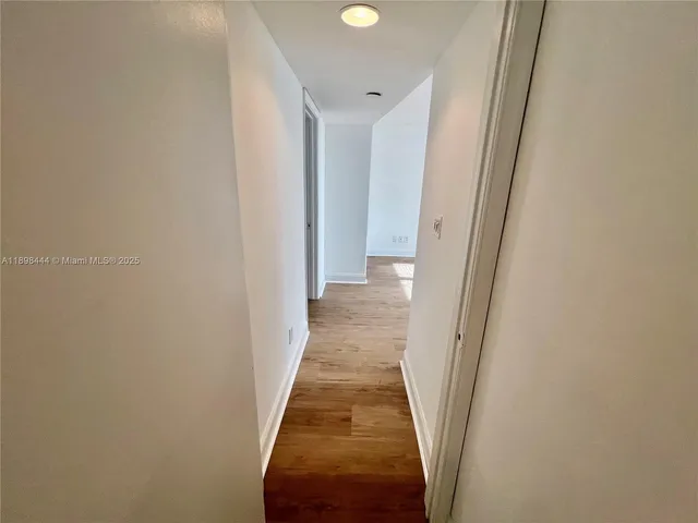 a view of a bedroom with wooden floor and bathroom