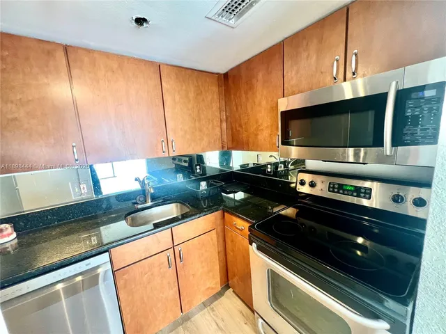a kitchen with stainless steel appliances a stove a microwave and a refrigerator