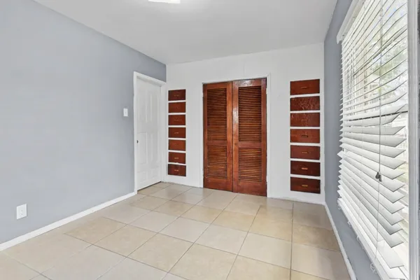 a view of an empty room with a fireplace and a window