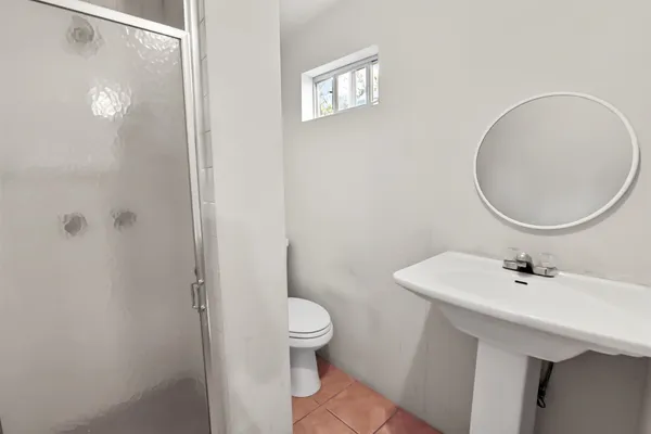 a bathroom with a sink a toilet and a mirror