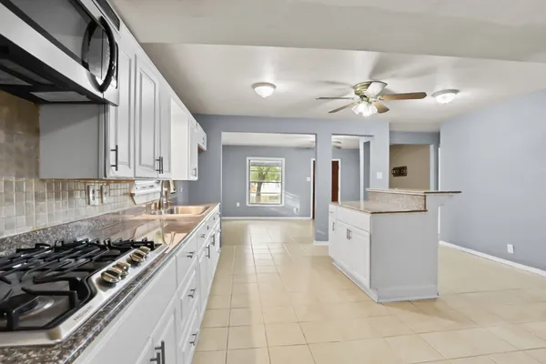 a large kitchen with a stove and cabinets