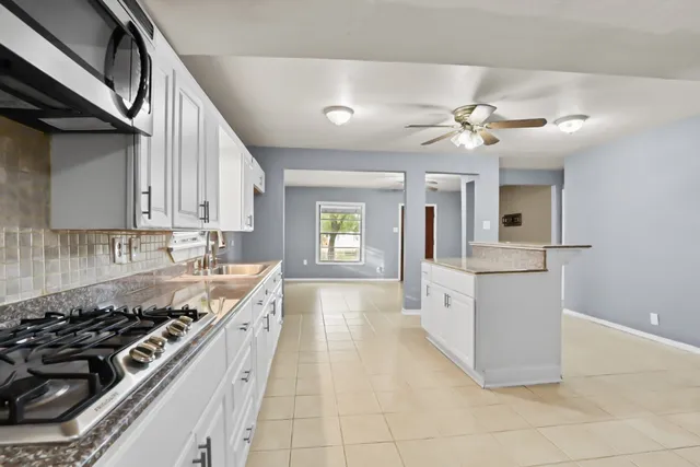 a kitchen with stainless steel appliances granite countertop a sink dishwasher stove and refrigerator
