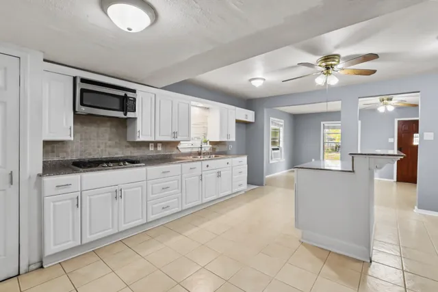 a view of a hallway with a chandelier fan and fire place