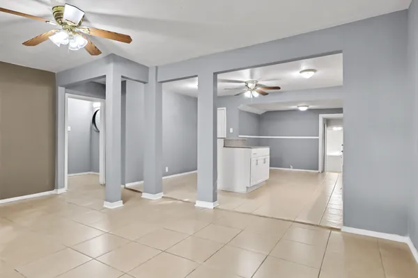 a view of a hallway with a chandelier fan and fire place