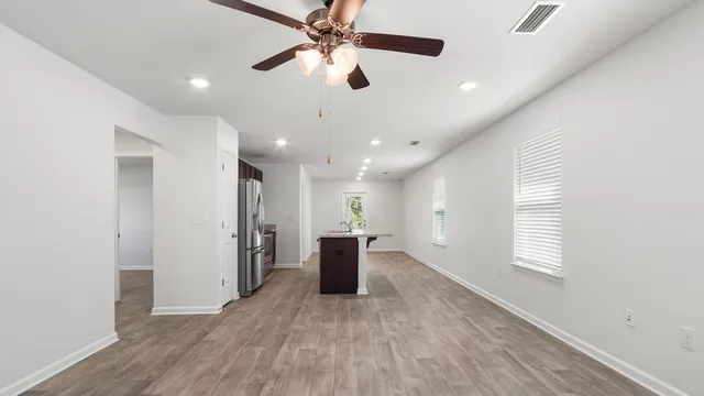 a view of a big room with wooden floor and a ceiling fan