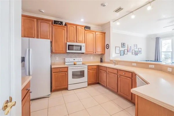 a kitchen with stainless steel appliances granite countertop a refrigerator sink and stove