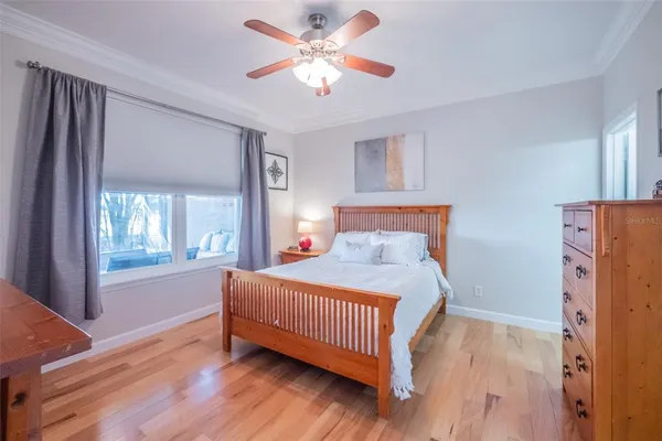 a bedroom with a bed a chandelier and a flat tv screen