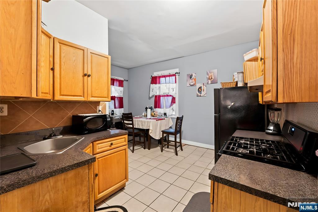 436 Ellison Street Paterson, NJ 07501 - Photo 11 of 47 a kitchen with stainless steel appliances granite countertop a stove a sink and a refrigerator