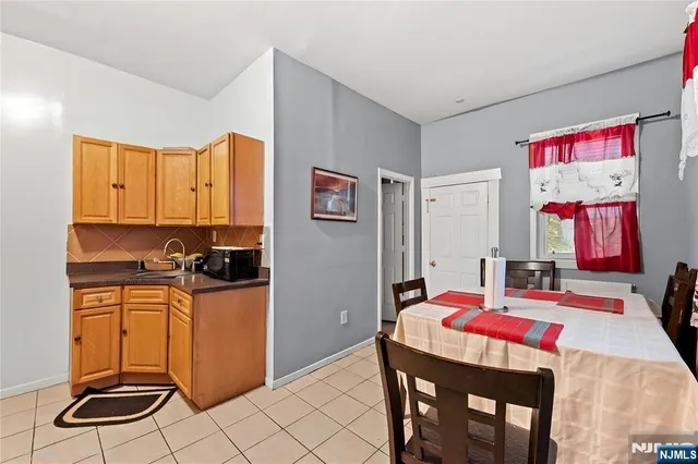 a kitchen with stainless steel appliances kitchen island granite countertop a refrigerator a stove a sink dishwasher with a dining table and chair