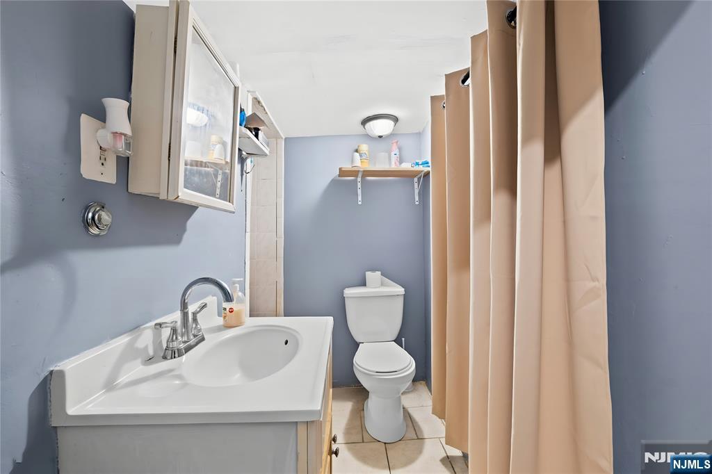 436 Ellison Street Paterson, NJ 07501 - Photo 17 of 47 a bathroom with a sink a toilet and a mirror
