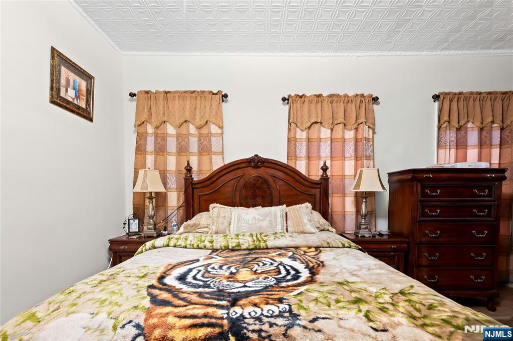 436 Ellison Street Paterson, NJ 07501 - Photo 22 of 47 a bed sitting in a bedroom next to a window with dresser