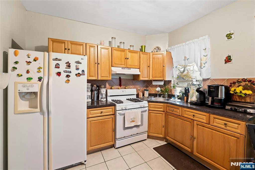 436 Ellison Street Paterson, NJ 07501 - Photo 24 of 47 a kitchen with stainless steel appliances a refrigerator sink and cabinets
