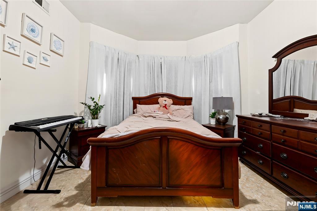 436 Ellison Street Paterson, NJ 07501 - Photo 27 of 47 a bedroom with a bed and a chair