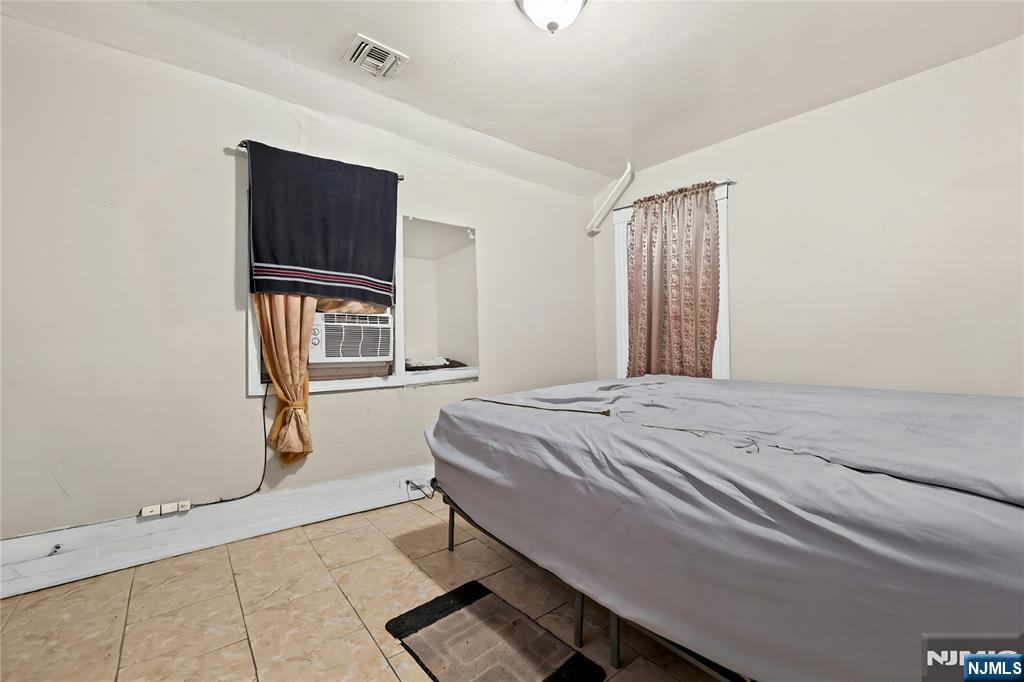 436 Ellison Street Paterson, NJ 07501 - Photo 31 of 47 a bedroom with a bed and a flat tv screen on dresser