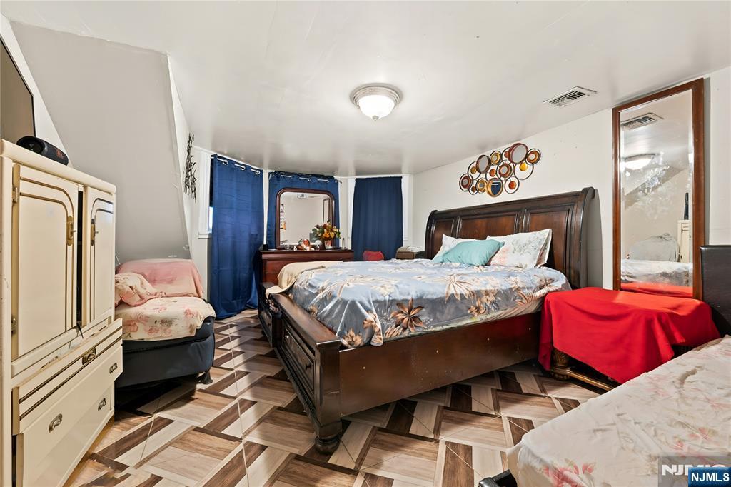436 Ellison Street Paterson, NJ 07501 - Photo 32 of 47 a bedroom with a bed and wooden floor