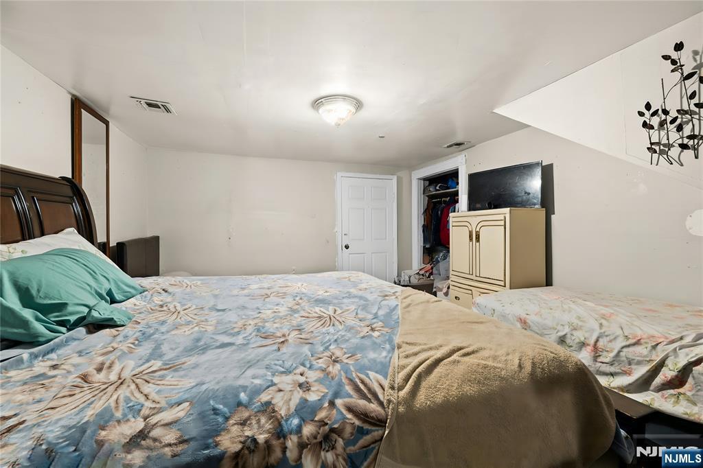 436 Ellison Street Paterson, NJ 07501 - Photo 34 of 47 a bedroom with a bed and a large mirror