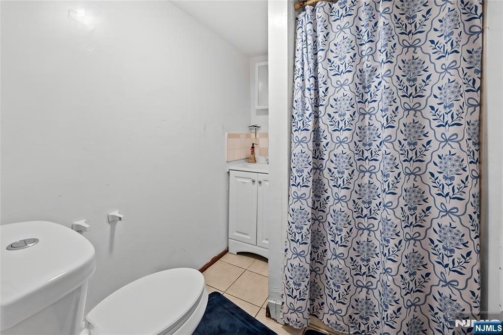 436 Ellison Street Paterson, NJ 07501 - Photo 37 of 47 a bathroom with a toilet and a shower curtain