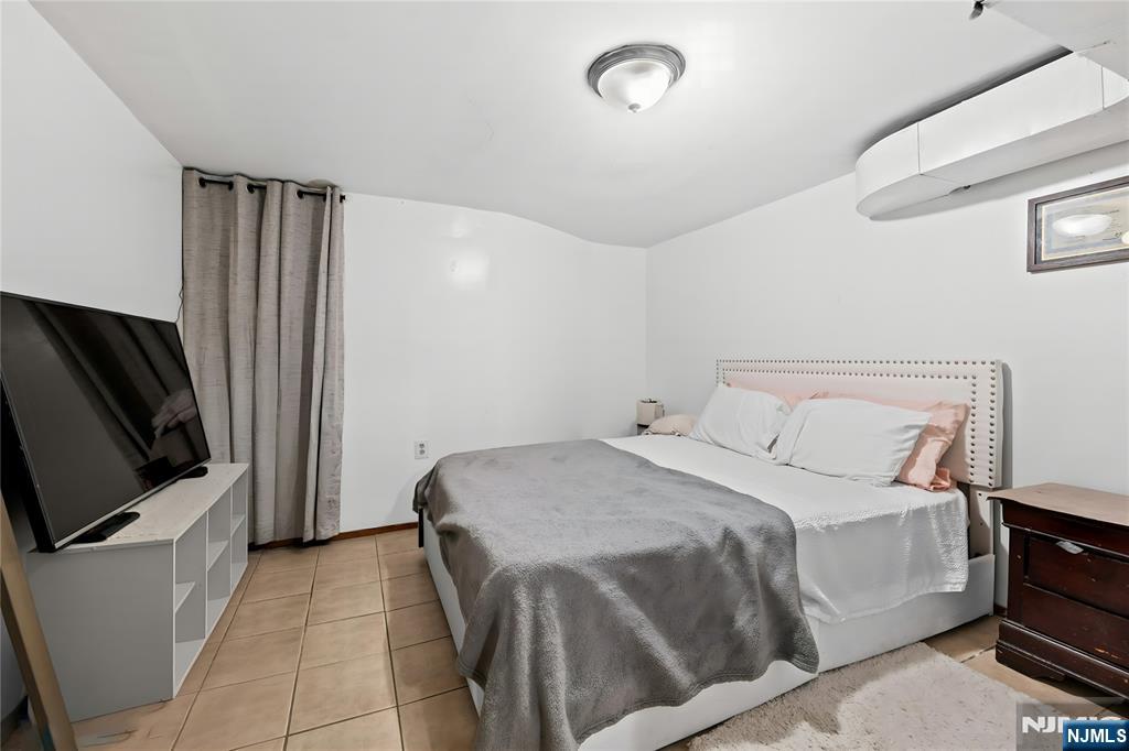 436 Ellison Street Paterson, NJ 07501 - Photo 38 of 47 a bedroom with a bed and a flat screen tv