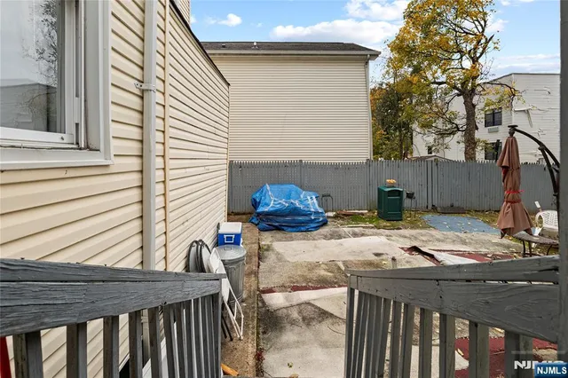 a view of a patio with table and chairs and wooden fence