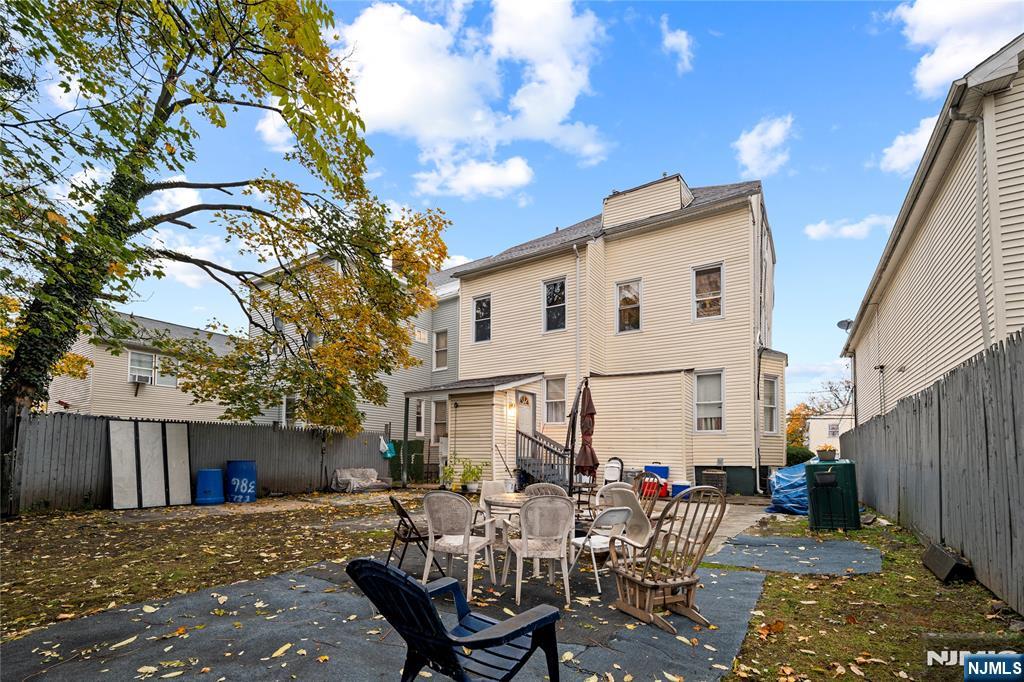 436 Ellison Street Paterson, NJ 07501 - Photo 45 of 47 a view of a patio with table and chairs and wooden fence