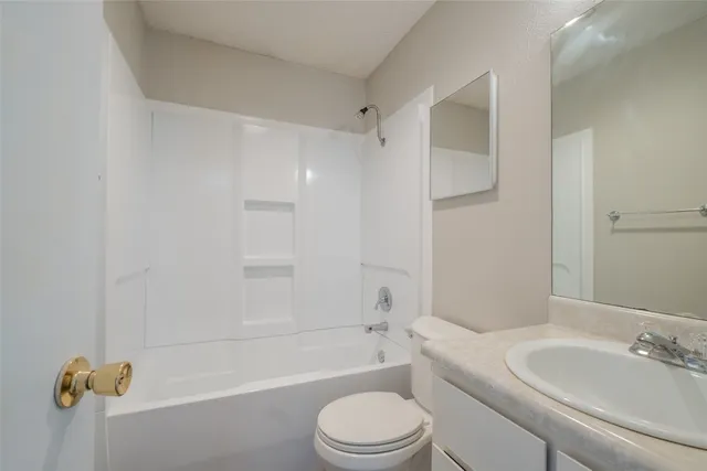 a bathroom with a toilet sink vanity tub and shower