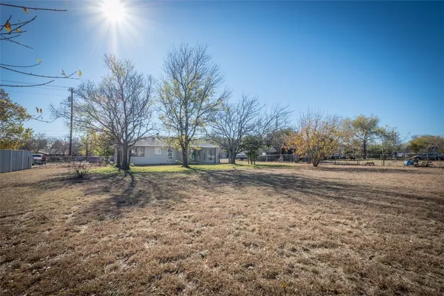 a view of a yard with a house and large tree