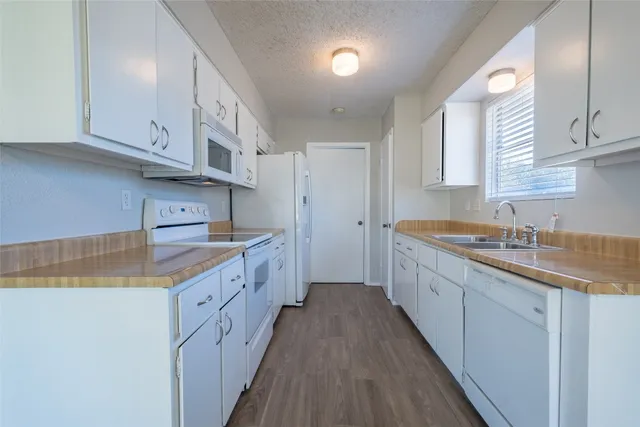 a kitchen with granite countertop a sink stove and cabinets