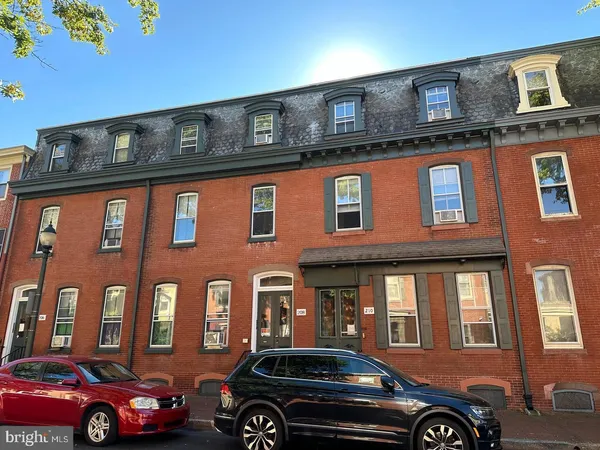 a front view of a building with car parked