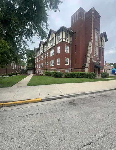 a view of a house with a yard and large trees