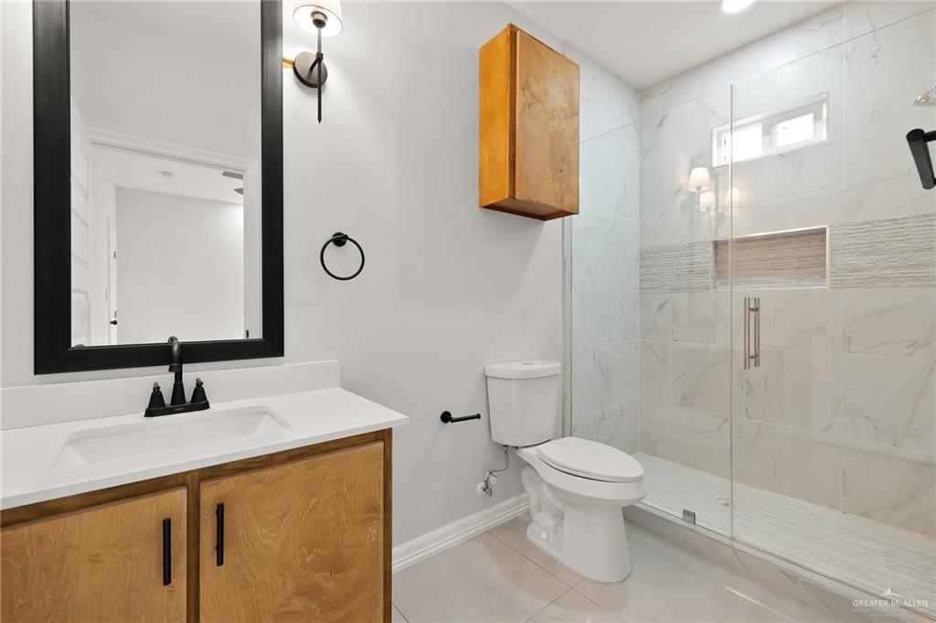 4217 Hummingbird Avenue McAllen, TX 78504 - Photo 14 of 15 Bathroom featuring vanity, a marble finish shower, and light tile patterned floors