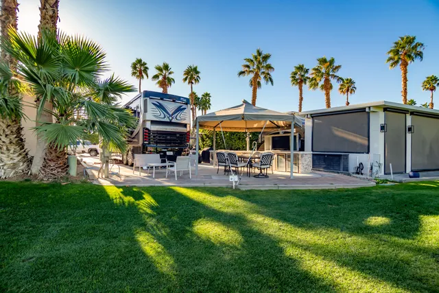 a view of an outdoor sitting area with a table and chairs under an umbrella