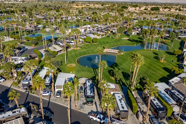 an aerial view of a residential apartment building with a yard and outdoor seating