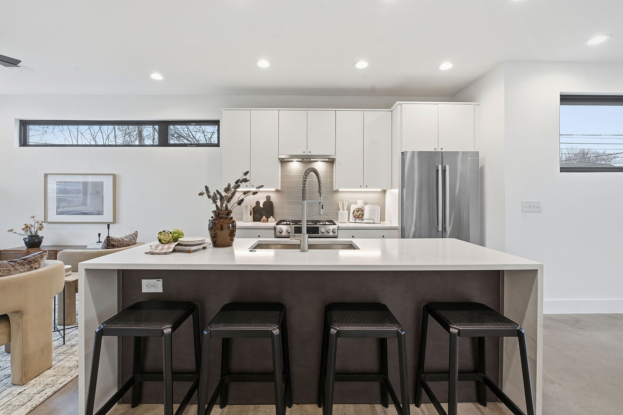 2411 Santa Rosa Street, Unit A Austin, TX 78702 - Photo 3 of 24 Two tone kitchen with a breakfast bar, freestanding refrigerator, recessed lighting, a large island, and light stone counters