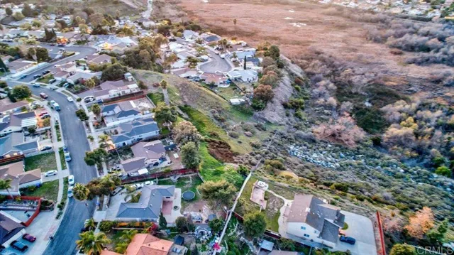 an aerial view of residential houses with outdoor space and trees