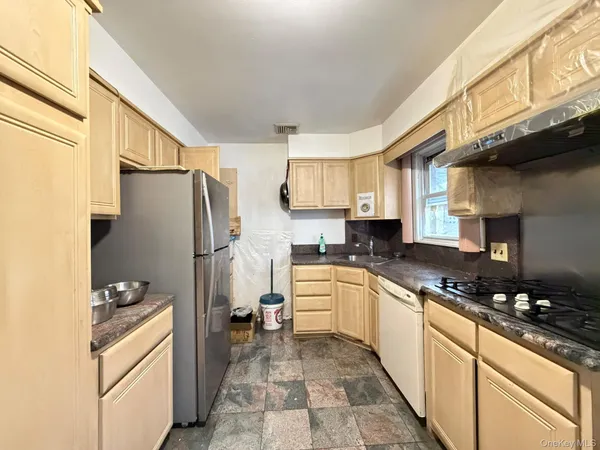 a kitchen with stainless steel appliances granite countertop a refrigerator stove and sink