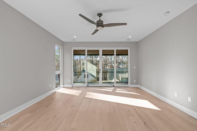 a view of an empty room with a window and a ceiling fan